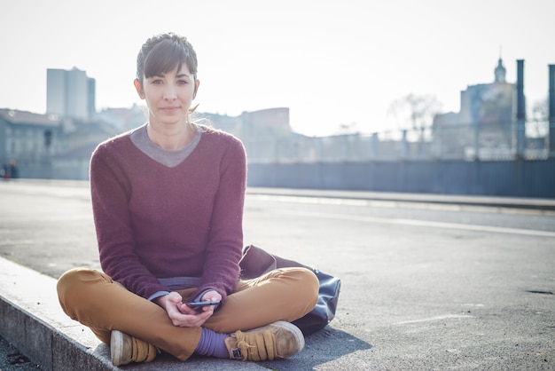 Foto jovem e bonita mulher hipster usando telefone inteligente