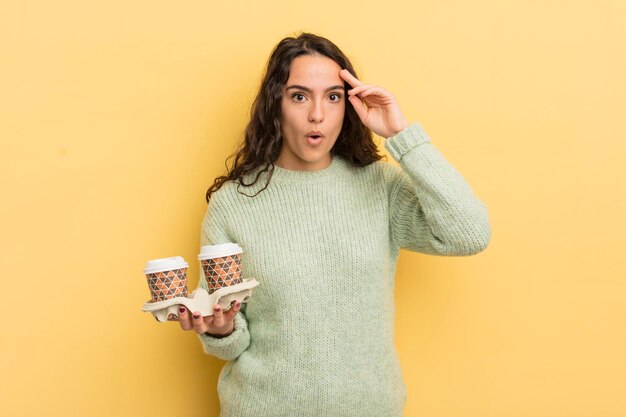 Jovem e bonita mulher hispânica parecendo surpresa ao perceber uma nova ideia de pensamento ou conceito tirar o conceito de café