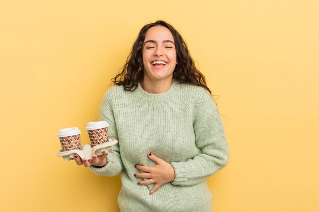 Jovem e bonita mulher hispânica rindo alto de alguma piada hilária, tire o conceito de café