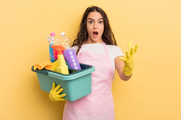 jovem e bonita mulher hispânica se sentindo extremamente chocada e surpresa. trabalho doméstico um conceito de produtos limpos