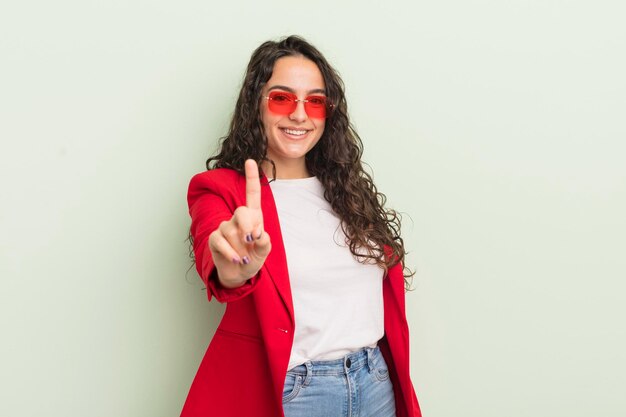 Jovem e bonita mulher hispânica sorrindo com orgulho e confiança, tornando a empresária legal número um