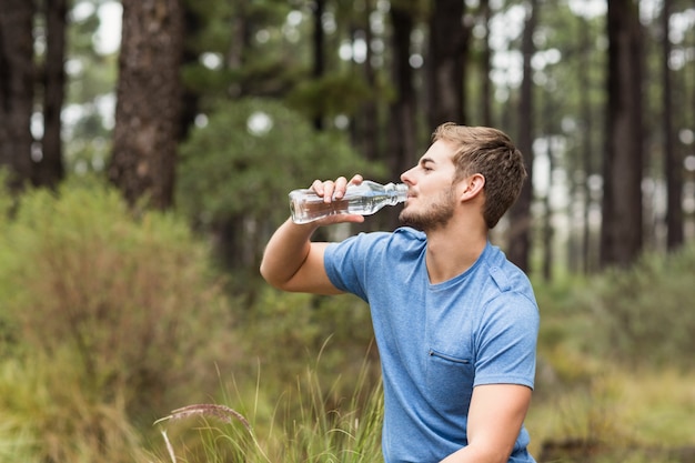 Foto jovem e bonito homem bebendo água