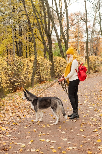 Jovem e cachorro andando no parque