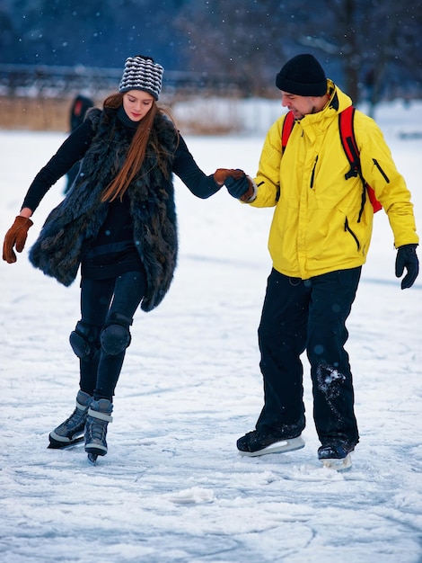 Jovem e companheiro de patinação no gelo no rinque de inverno coberto de neve em Trakai, Lituânia.