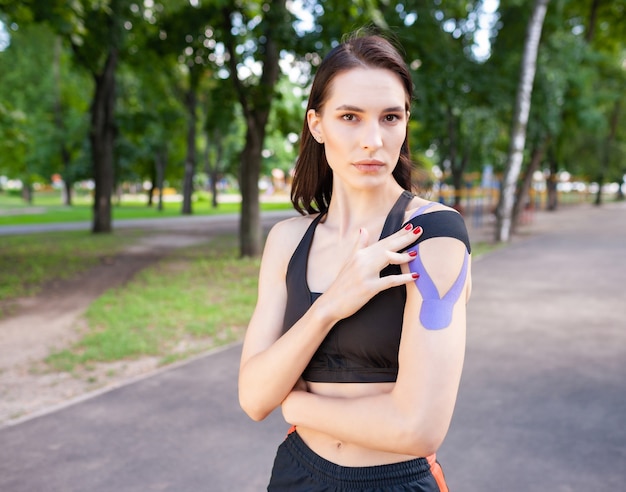 Jovem e deslumbrante mulher musculosa usando roupa esportiva preta