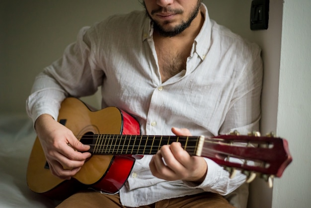 Jovem e elegante homem tocando violão