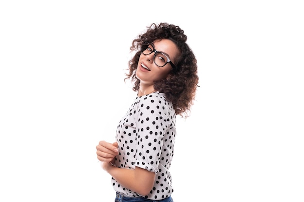 Foto jovem e elegante mulher caucasiana com cabelos encaracolados parece feliz e confiante