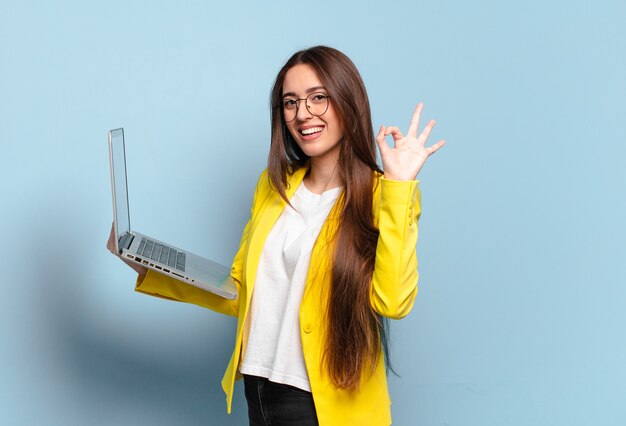 Jovem e linda freelancer segurando um laptop