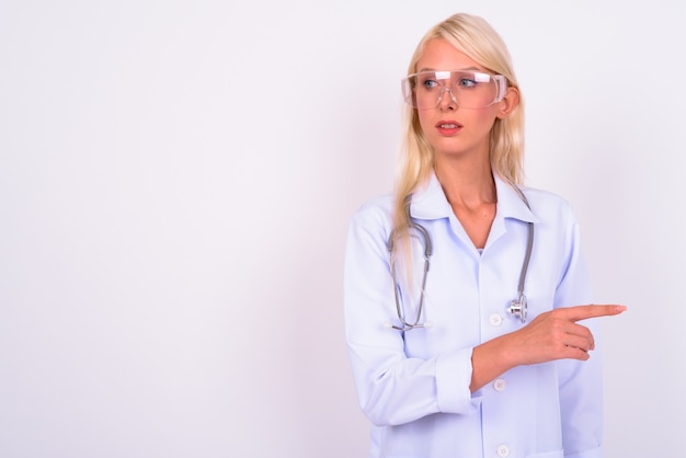 jovem e linda loira médica como cientista usando óculos de proteção contra o espaço em branco