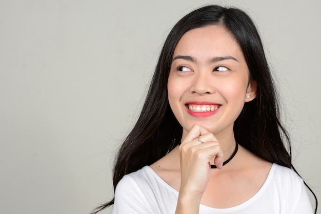 jovem e linda mulher asiática contra o espaço em branco