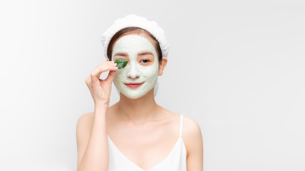 Jovem e linda mulher com máscara facial de lama azul terapêutica Tratamento de spa, autocuidado e pele saudável Copiar fundo branco do espaço