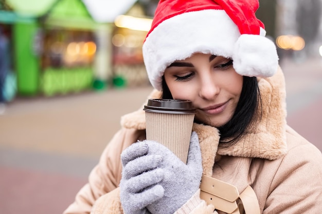 Jovem e linda mulher segurando uma bebida quente com café