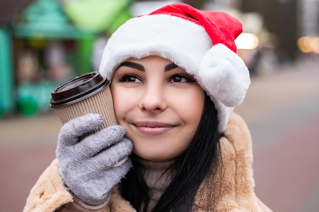 Jovem e linda mulher segurando uma bebida quente com café