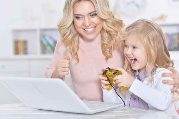 Jovem e menina jogando videogame no laptop