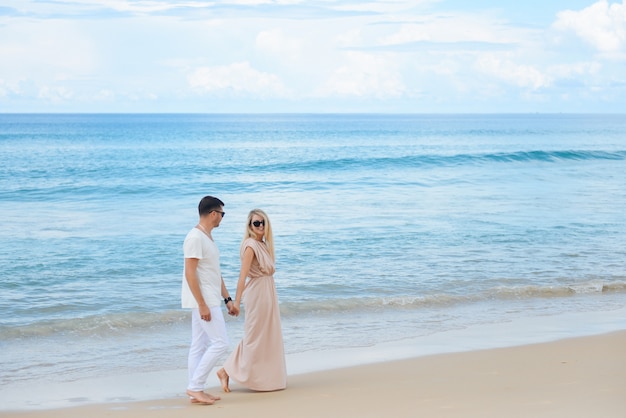 Jovem e mulher caminhar na praia