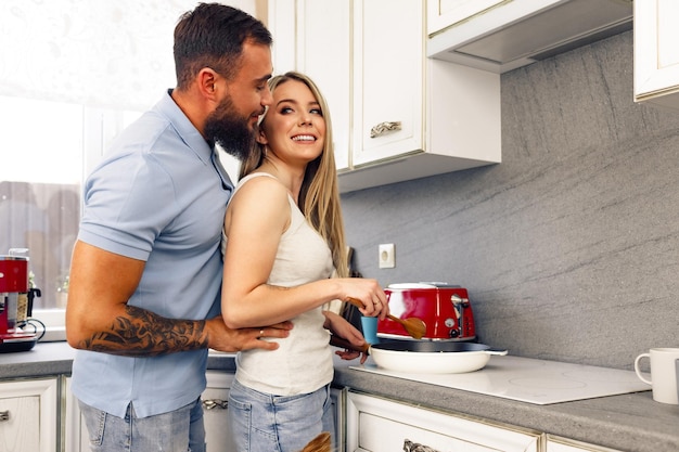 Jovem e mulher cozinhando comida juntos na cozinha casal feliz preparando comida