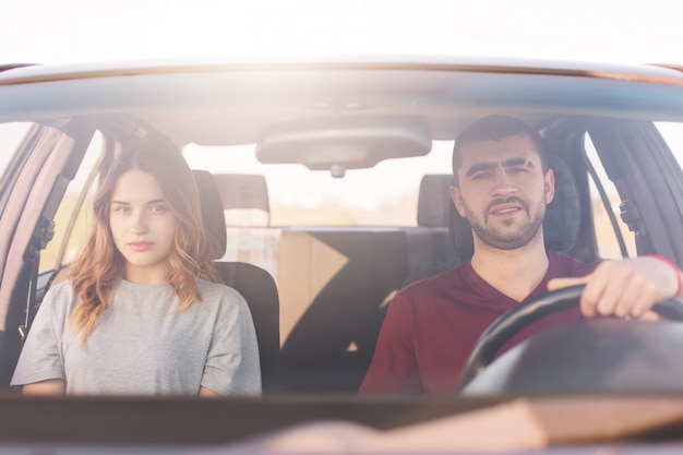 Jovem e mulher sentada no carro