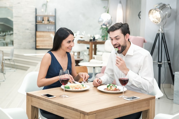 Jovem e mulher sentados no conceito de restaurante