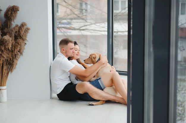 Jovem e uma mulher brincando em casa com o cachorro