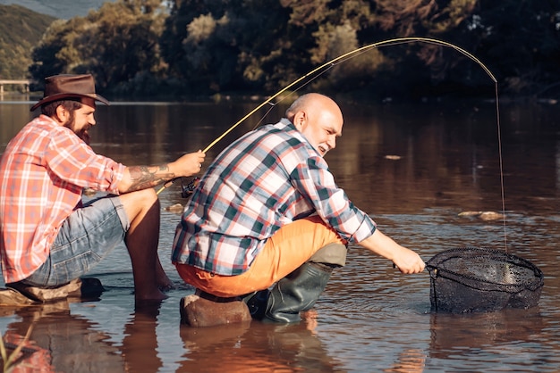 Foto jovem e velho maduro pesca com mosca. homem pescando e relaxando enquanto desfruta do hobby. retrato de