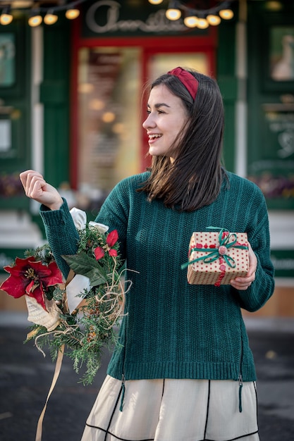 Jovem elegante com uma guirlanda de Natal nas cores vermelha e verde