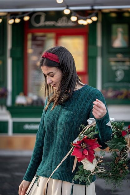 Jovem elegante com uma guirlanda de Natal nas cores vermelha e verde