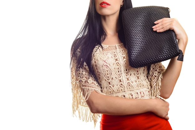 Jovem elegante de saia vermelha segurando uma bolsa de couro preto