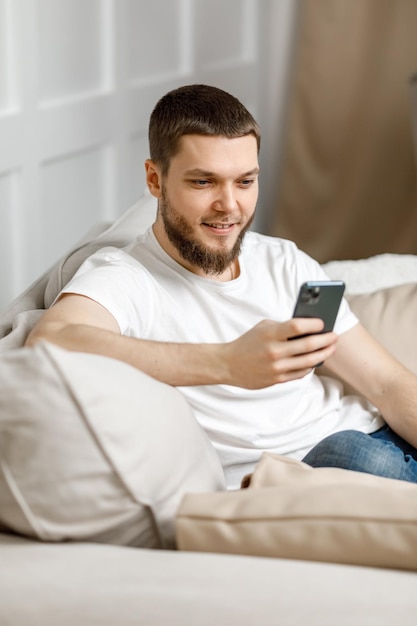 Jovem em casa no sofá falando em videochamada do telefone