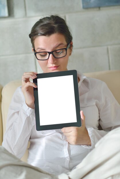 Jovem em casa relaxando em sua sala lendo um tablet digital PC navega na internet e trabalha