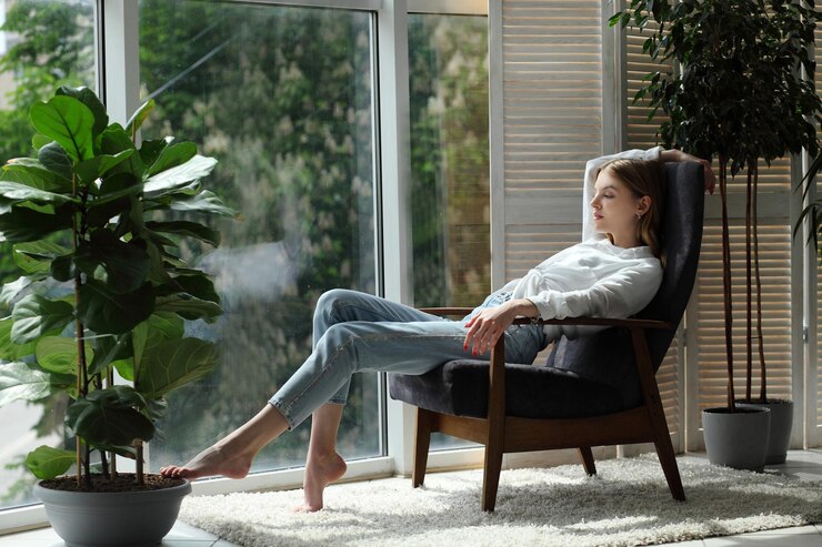 Foto jovem em casa sentada na cadeira moderna perto da janela relaxando na sala de estar