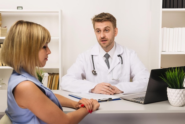 Jovem em consulta com um cirurgião ou terapeuta em seu consultório Foco seletivo no médico
