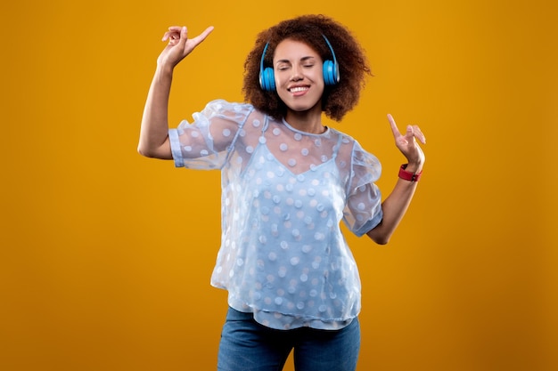 Jovem em fones de ouvido ouvindo música e dançando