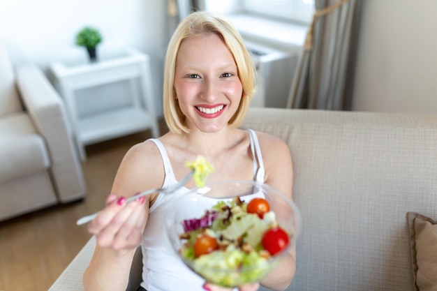 Jovem em forma comendo salada saudável após o treino Fitness e conceito de estilo de vida saudável jovem saudável comendo salada verde