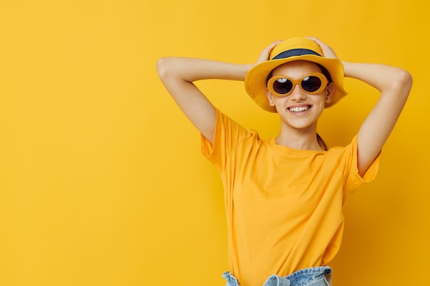 Jovem em óculos de sol uma camiseta amarela e chapéu estilo de vida de verão inalterado