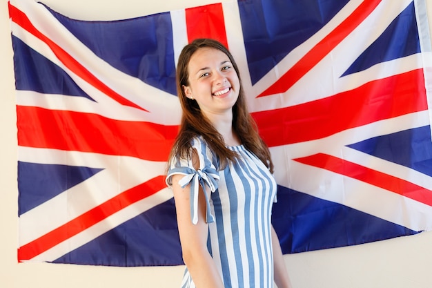 Jovem em pé contra a bandeira do Reino Unido