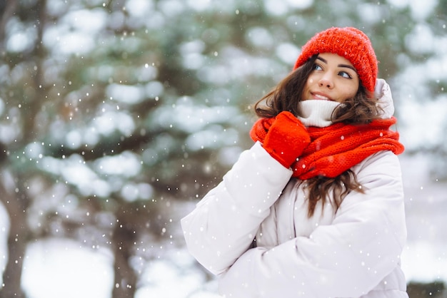 Jovem em roupas de inverno contra o pano de fundo da floresta nevada Férias da natureza