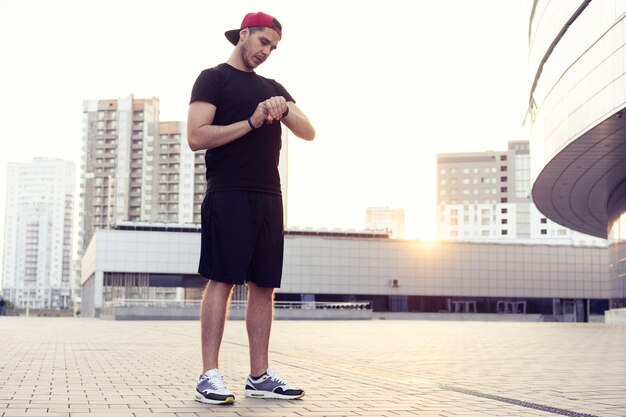 Jovem em roupas esportivas. Homem urbano, prepare-se para correr na cidade. Malhar urbano