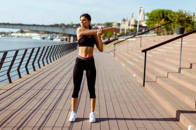 Jovem em roupas esportivas se exercitando em um passeio fluvial