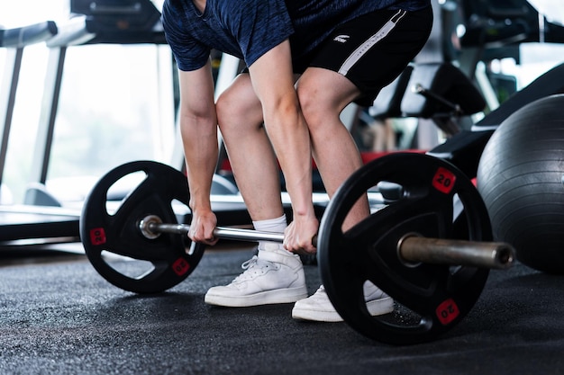 Jovem em roupas esportivas se exercitando na academia