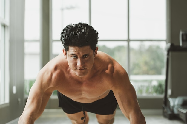 Jovem em treino push up no ginásio em casa