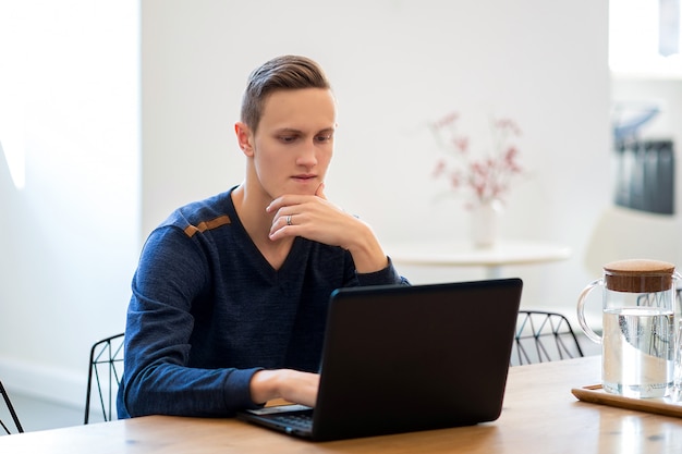 Jovem em um café, trabalhando em um laptop