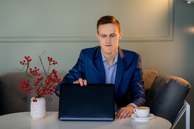 Jovem em um café, trabalhando em um laptop