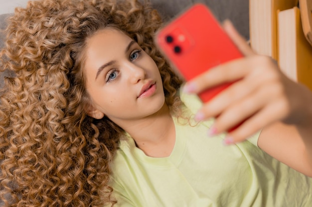 Jovem em uma camiseta amarela está segurando um smartphone Foto de alta qualidade