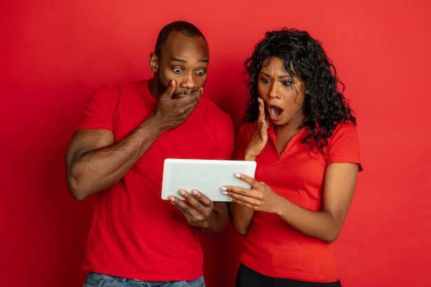 Jovem emocional afro-americano e mulher no vermelho