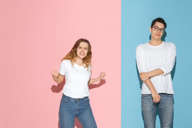 Jovem emocional e mulher em fundo rosa e azul