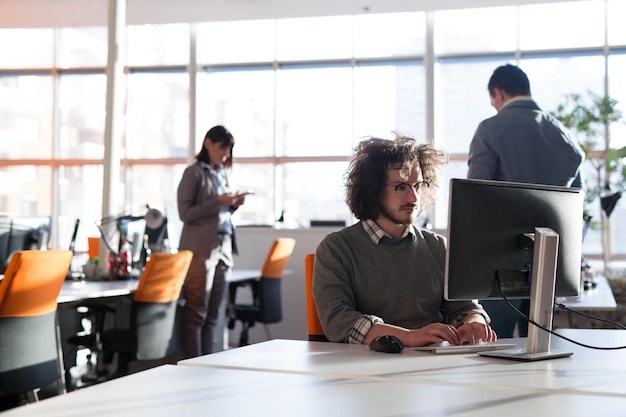 Jovem empreendedor freelancer trabalhando usando um computador no espaço de coworking