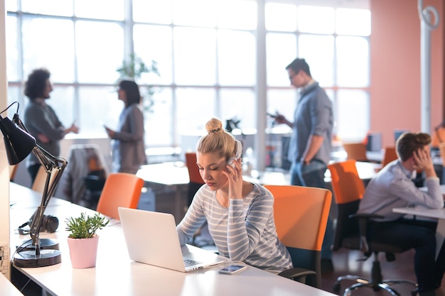 Jovem empreendedora freelancer trabalhando usando um laptop no espaço de coworking