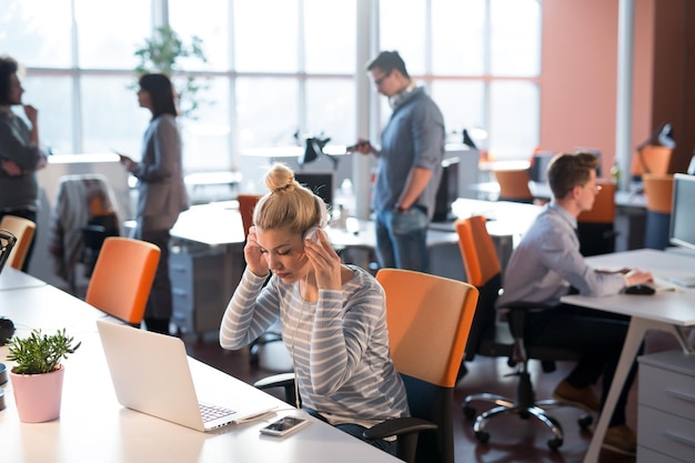 Jovem empreendedora freelancer trabalhando usando um laptop no espaço de coworking