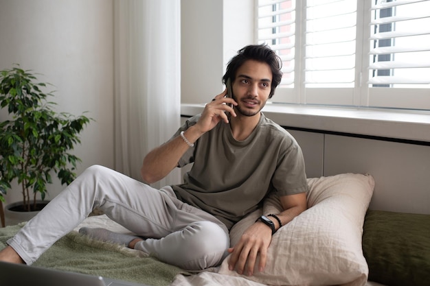 Jovem empregado ocupado contemporâneo ou freelancer falando no celular