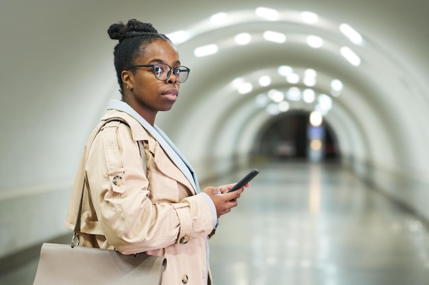 Jovem empresária afro-americana com smartphone olhando para frente